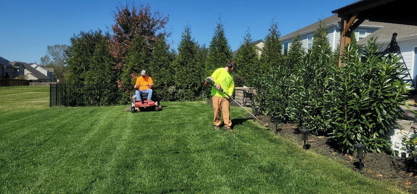 Elevate-Pros crew mowing and edging a residential backyard