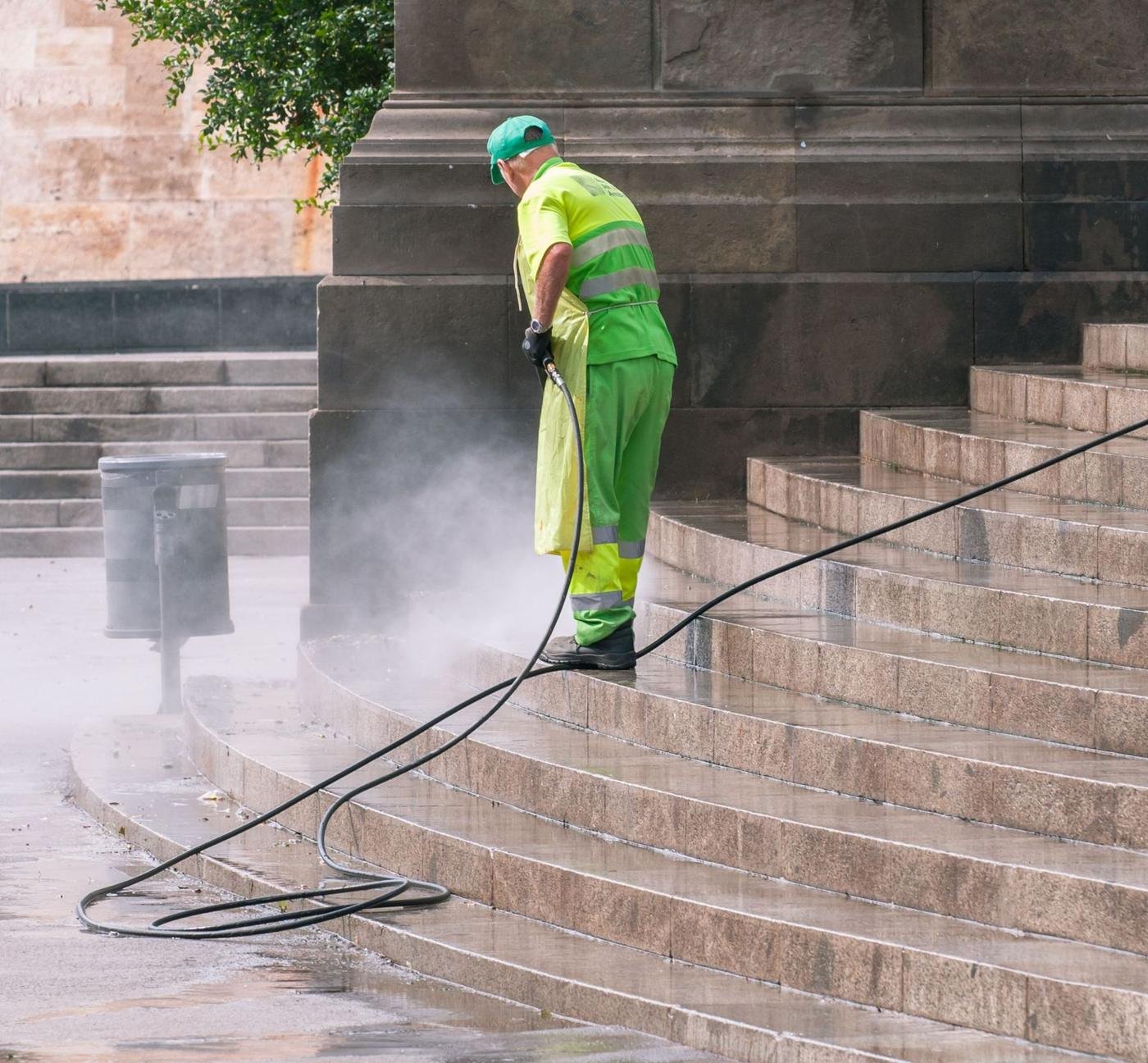 Pressure washing exterior stone steps and entryway at a commercial property